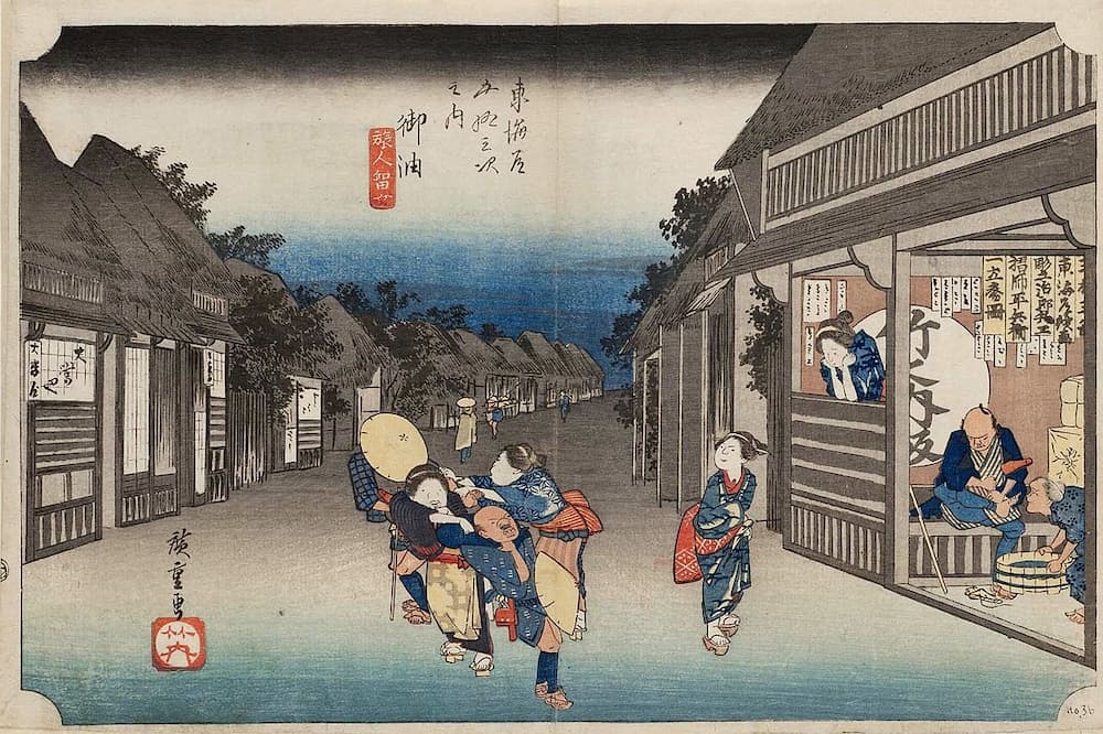 Hiroshige's woodblock print of Goyu post town on the Tōkaidō road, with travelers along the inn-lined street at dusk