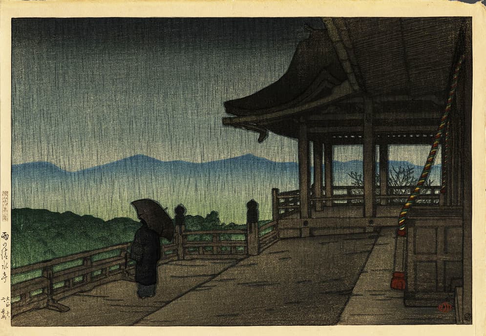 Woodblock print of a lone figure with an umbrella standing on a temple veranda in heavy rain, with misty green mountains in the distance